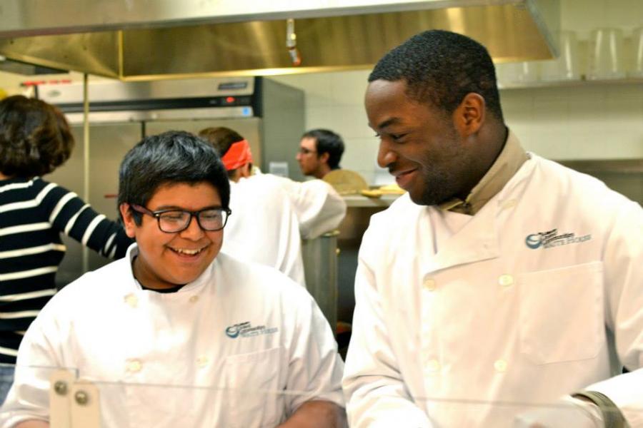 an adult and a child wearing cooking uniforms